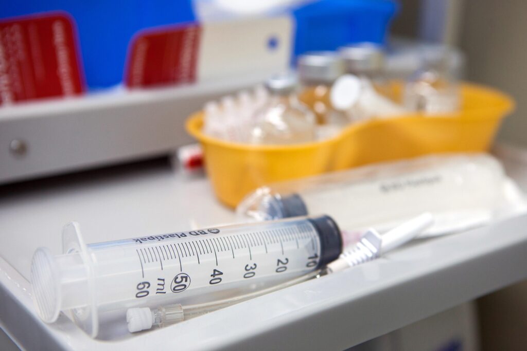 Ensemble de matériel pour une injection comme des seringues, un bac jaune pour les aiguilles usagées et des bouteilles de solutions
